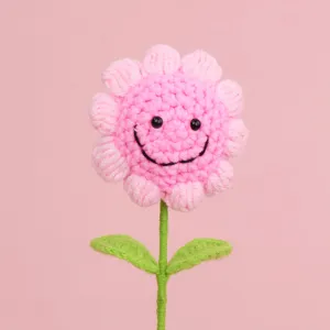 Handmade pink crochet flower bouquet detail featuring a charming smiley face design