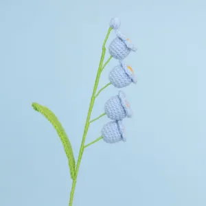 Close-up of handmade crochet lily of the valley with light blue bell flowers
