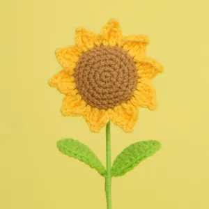 Close-up of a handmade crochet sunflower with intricate yellow knitted petals.