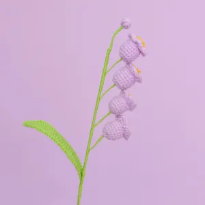 Detailed macro shot of hand-knitted lavender lily of the valley crochet flowers