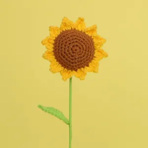 Macro detail of a single handmade yellow crochet sunflower featuring intricate stitch work