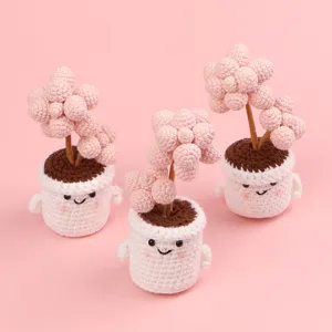 Detailed macro view of three handmade pink crochet succulent plants in cute pots