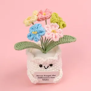 Detail of handmade crochet forget-me-not potted plant with inspirational card