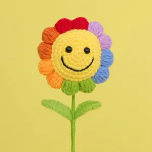 Detailed macro view of handmade crochet flower with rainbow petals and smiley face