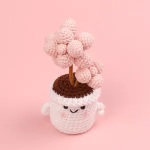 Handmade pink crochet succulent potted plant with cute smiling face white pot.