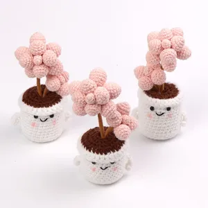 Detailed view of three handmade pink crochet peach egg succulent potted plant ornaments.