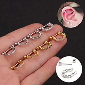 Detail of stainless steel cartilage piercing studs with screw balls and sparkling zircons