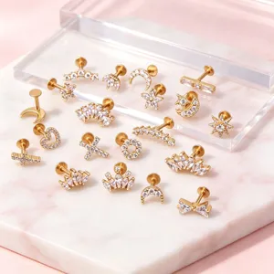 Close-up of assorted gold stainless steel piercing studs with CZ crown and star shapes
