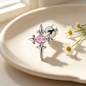 Detailed macro shot of a retro cross stud earring with square pink zircon gemstone