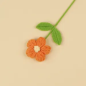 Detailed hand-crocheted yarn puff flower with vibrant orange petals and green leaves