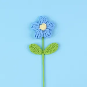 Macro view of a handcrafted blue crochet puff flower with intricate knit texture.