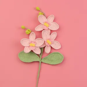 Detailansicht einer handgehäkelten rosa Phalaenopsis-Orchidee auf einem rosa Hintergrund