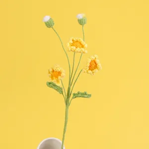 Detailansicht einer handgefertigten gelben Häkelblume mit weicher Garnstruktur und Stiel