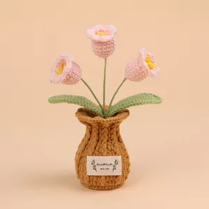 Detailopname van een handgemaakte gehaakte bloempot met roze bloemen en een label