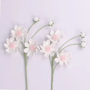 Detailed close-up shot of handcrafted white and pink crochet cosmos yarn flowers