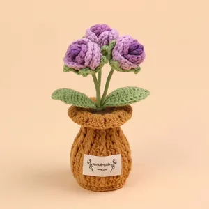 Detailopname van een handgemaakte paarse gehaakte bloem in pot met stoffen label