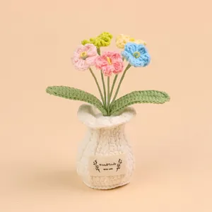 Dichtbij van een kleurrijk handgebreid gehaakt bloemenboeket in een witte pot