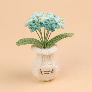 Detailopname van gehaakte bloemen in een witte gebreide pot met HandMade-label