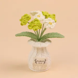 Detailweergave van handgebreide lelietje-van-dalen bloemen in een witte gehaakte pot