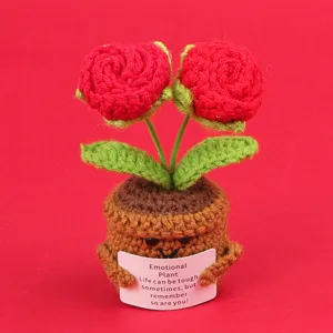 Detail of handmade crochet red rose potted plant holding a motivational message card