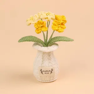 Close-up van handgemaakte gehaakte bloemen in een witte gebreide vaas gedetailleerd beeld