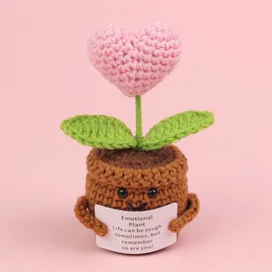 Detailed view of crocheted heart plant in a pot holding an inspirational card.