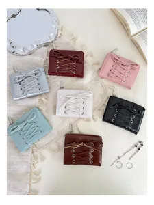 Detail view of multi-color Korean style lace-up bow small wallets on a decorative background