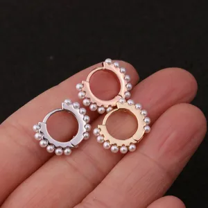 Detail shot of three pearl hoop earrings in silver, gold and rose gold finishes