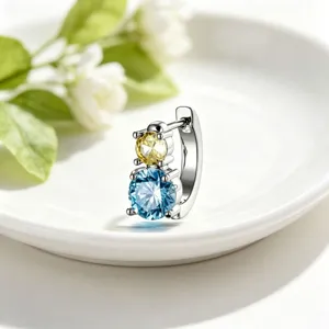 Detail of silver titanium hoop earring with stacked yellow and blue cubic zirconia stones