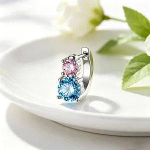 Macro detail of 316L steel hoop earring featuring stacked pink and blue crystals.