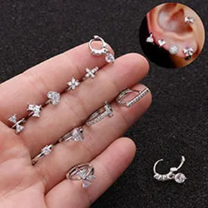 Close-up of assorted stainless steel cartilage earrings with zircon butterfly and heart