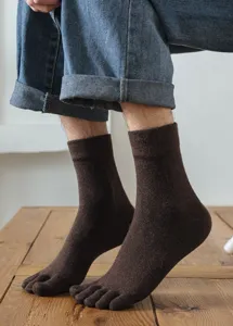 Detail shot of thick brown wool toe socks worn on a wooden table, cozy and warm.