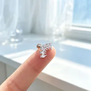 Detailed view of curved marquise zirconia ear stud on finger tip with bright natural lighting