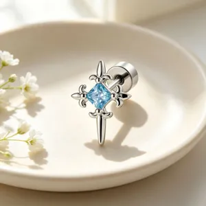 Macro view of vintage cross zircon stud earring with light blue center stone