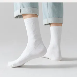 Detail view of classic solid white ribbed crew socks worn with light jeans, comfortable fit.