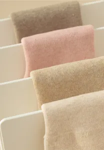 Close-up detail van dikke wintertextiel sokken netjes weergegeven op een wit opbergrek.