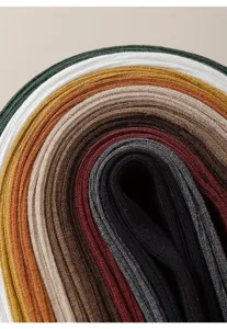 Calze a coste colorate arrotolate strette, primo piano che mostra ricca varietà di colori.