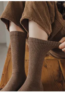 Close-up of brown ribbed cotton socks, elastic calf-high knit detail for autumn winter wear.