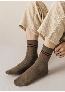 Detailed close-up of brown ribbed mid-calf socks featuring stylish double stripes design.