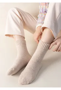 Primo piano dettagliato di calzini invernali spessi e caldi da donna in morbido beige.