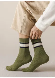 Gros plan détaillé de chaussettes pour hommes vert armée avec des rayures blanches.