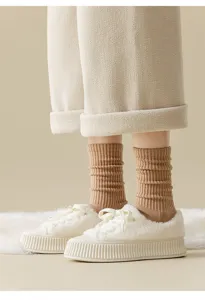 Cozy winter detail view featuring fluffy platform sneakers and warm knit socks for women.