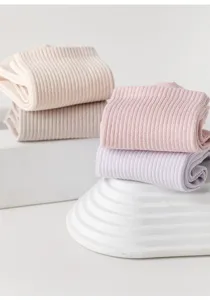 Close-up detail of solid color ribbed mid-tube socks in pastel taro purple, pink, and beige.
