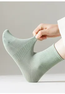 Detail shot of breathable cotton mesh mid-tube socks in light green, showing elastic stretch.