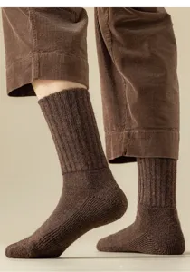 Nahaufnahme dicker Woll-Thermosocken in Cordhose, gemuetliche Wintertextur Details.