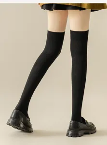 Detailed close-up view of black ribbed over-the-knee long socks styled with pleated skirt.