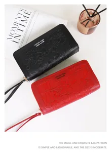 Dettaglio di portafogli vintage in rosso e nero con fiori in rilievo e doppia zip