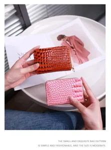 Nahaufnahme der Kroko-Textur auf rosa und orangefarbenen Akkordeon-Kartenhaltern