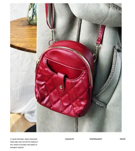 Detailed view of a red quilted mini backpack crossbody bag for women in soft leather