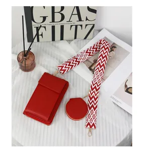 Detailed close-up view of a red leather crossbody phone bag with a patterned wide strap